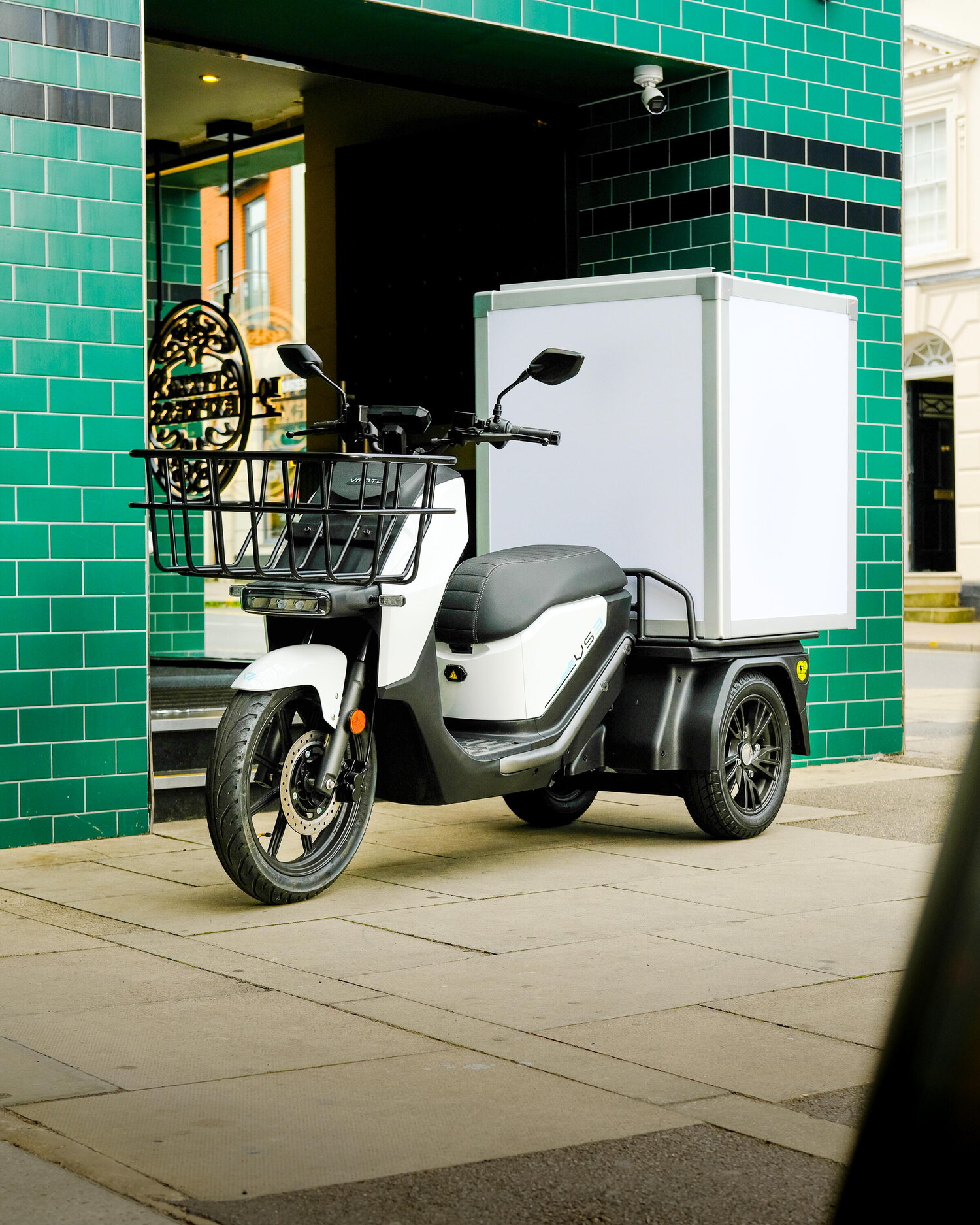 Cargo-scooter van Vmoto - cargo-scooter staat voor een gebouw